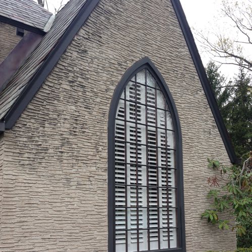outdoor view of stone home with plantation shutters